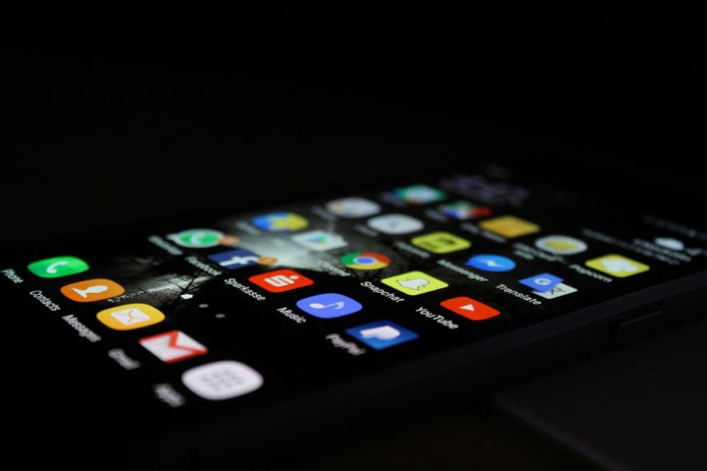 En mobiltelefon med många appikoner på skärmen
